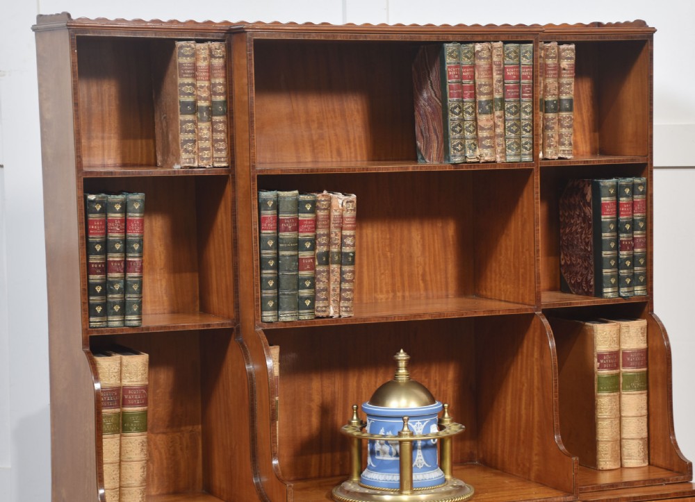 A matching pair of open satinwood breakfront bookcases featuring stepped waterfall shelving, inlaid drawers, and oval panel cupboard doors. View II