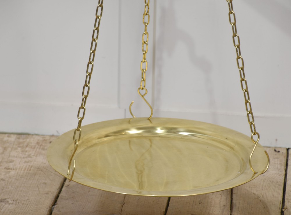 A floor-standing brass balance scale featuring a bull head finial, turned central column, horizontal beam, and two circular brass pans suspended by chains. View III