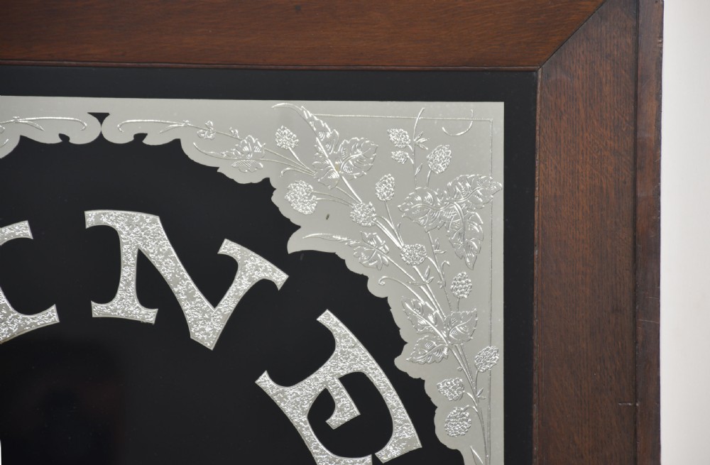 A square Victorian advertising mirror framed in dark wood, featuring silvered arched lettering reading FINE TEAS on a black painted glass ground. View IV