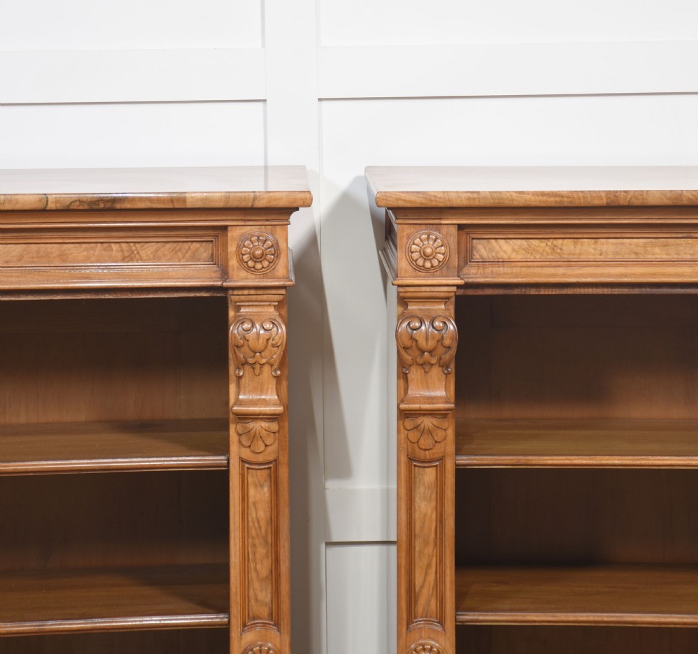 A pair of 19th-century walnut open bookcases featuring carved pilasters, rosette details, adjustable shelves, and heavy plinth bases. View III