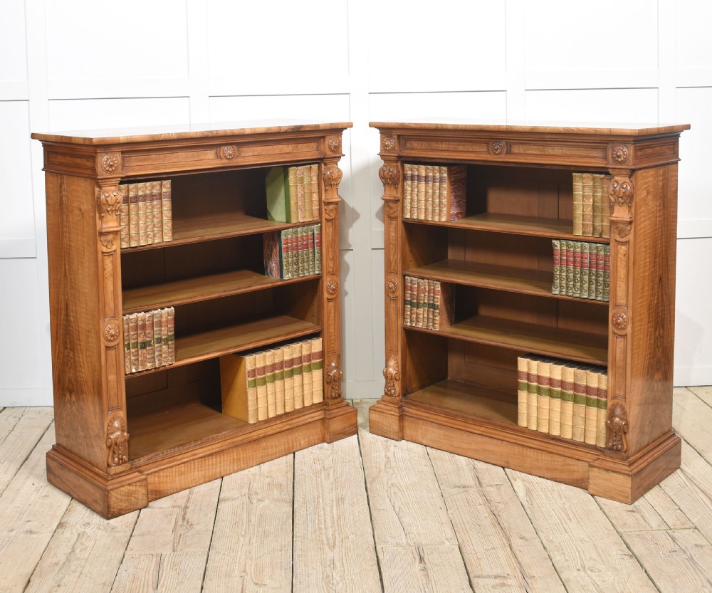 A pair of 19th-century walnut open bookcases featuring carved pilasters, rosette details, adjustable shelves, and heavy plinth bases. View XIII