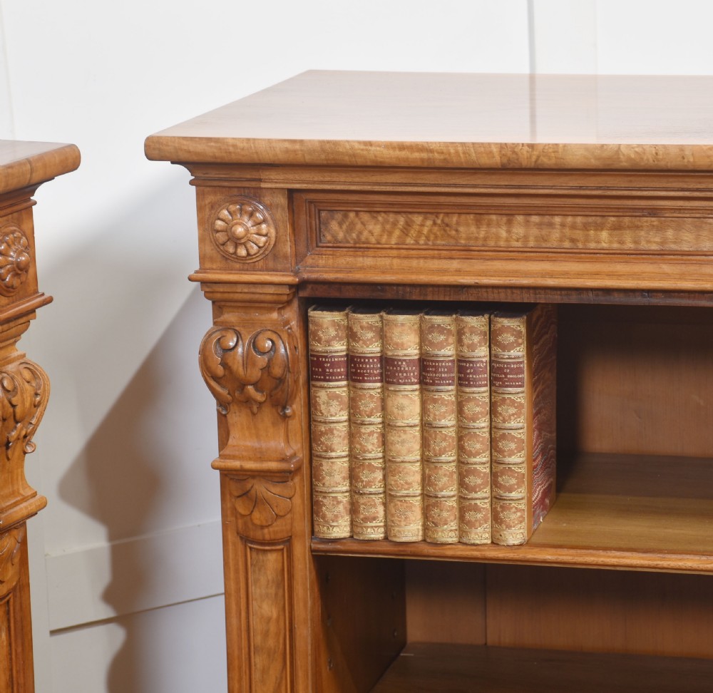 A pair of 19th-century walnut open bookcases featuring carved pilasters, rosette details, adjustable shelves, and heavy plinth bases. View XVIII