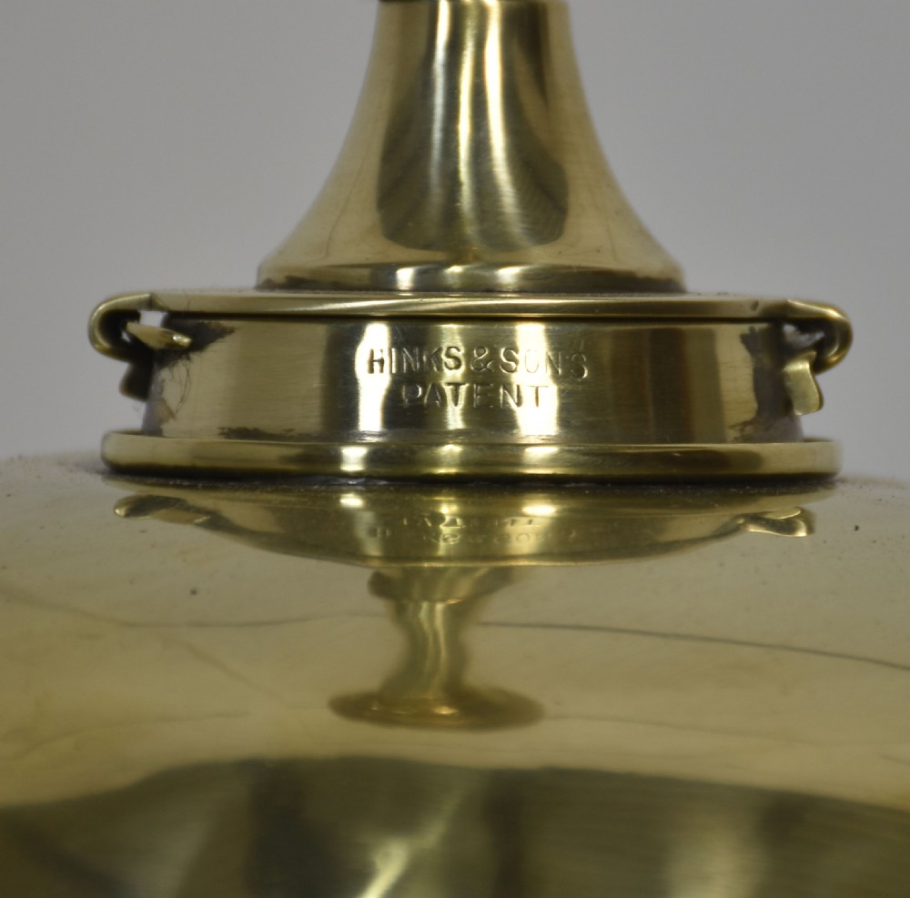 A tall Victorian polished brass standard lamp featuring a fluted column, Corinthian capital, a decorative urn reservoir, and a stepped square base adorned with laurel wreath motifs. View XVI