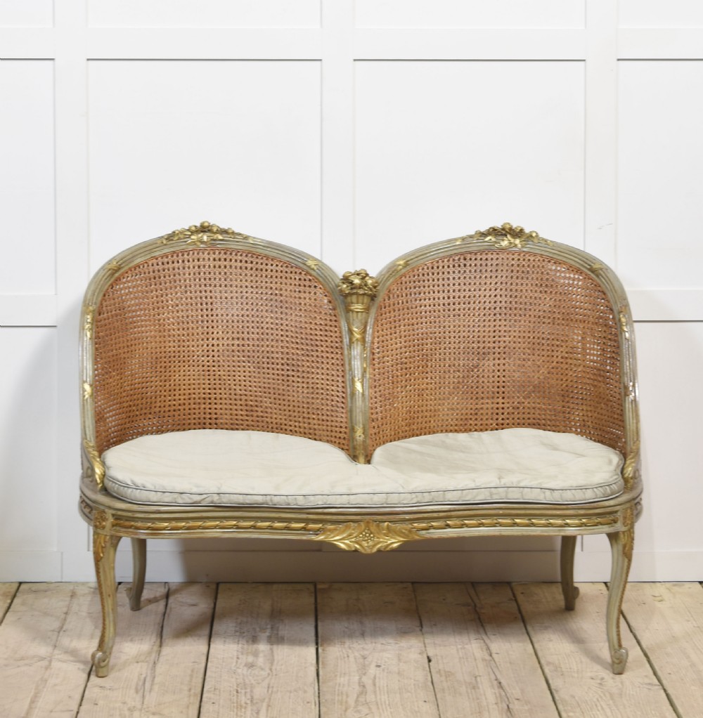 Painted and parcel gilt caned canape settee