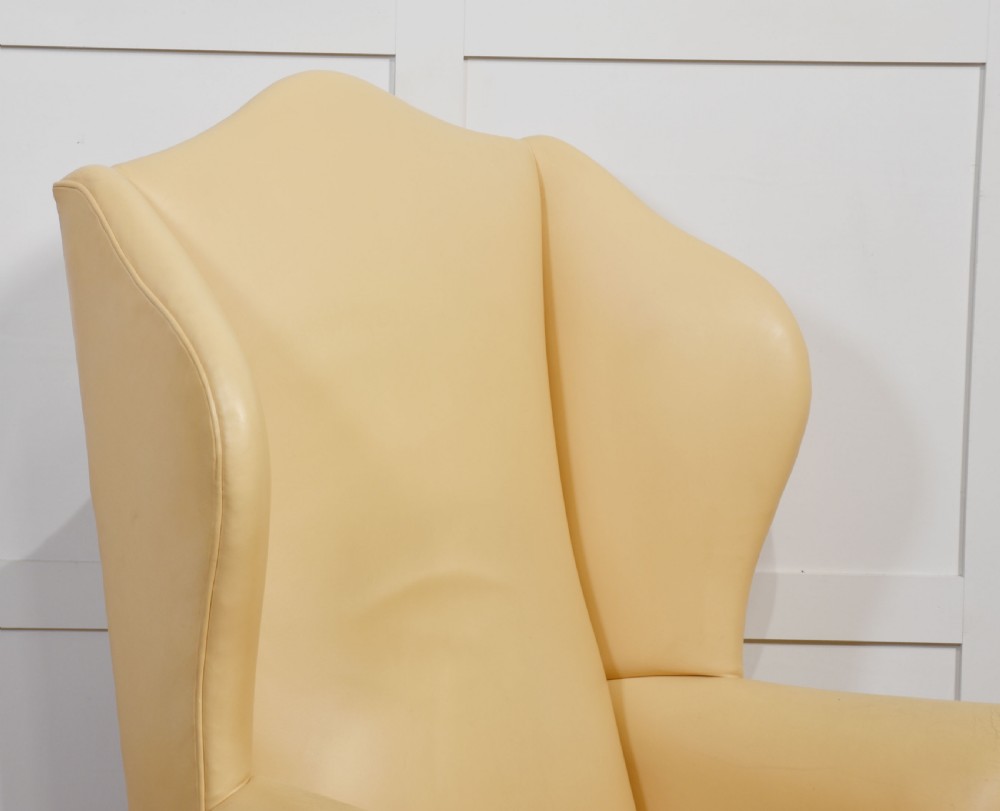 A Georgian style wingback armchair upholstered in cream leather with cabriole front legs. View III