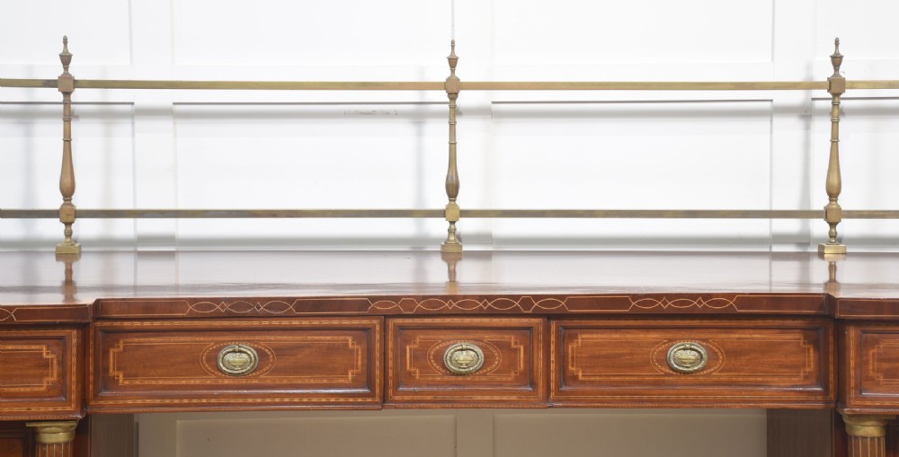 A 19th-century mahogany pedestal sideboard with satinwood oval panel inlays, reeded columns, five upper drawers, and a top brass gallery rail. View III