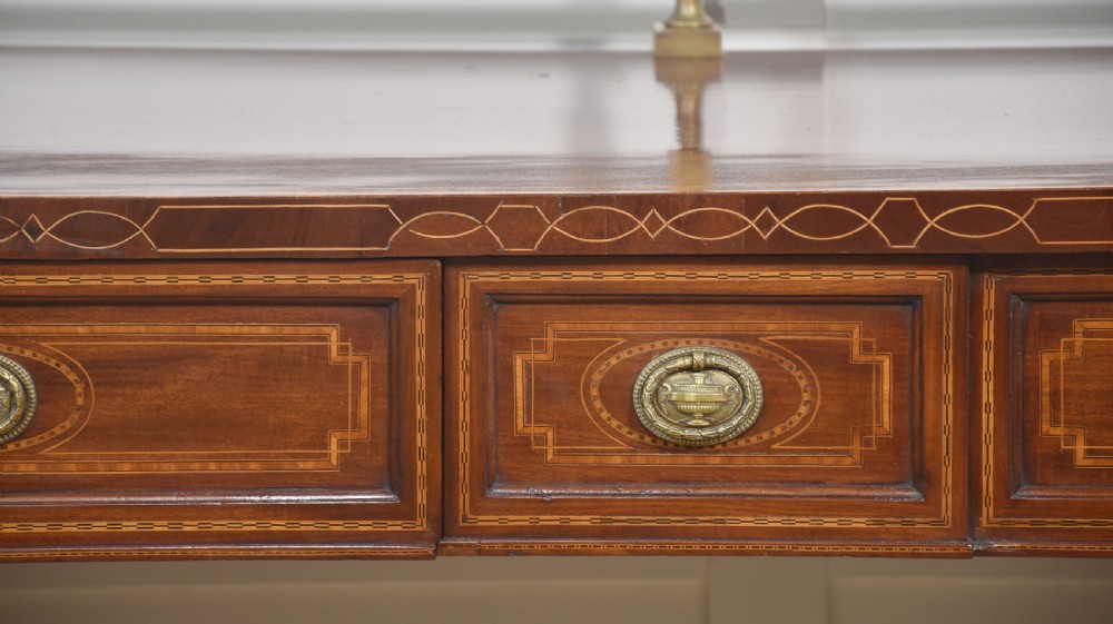 A 19th-century mahogany pedestal sideboard with satinwood oval panel inlays, reeded columns, five upper drawers, and a top brass gallery rail. View V