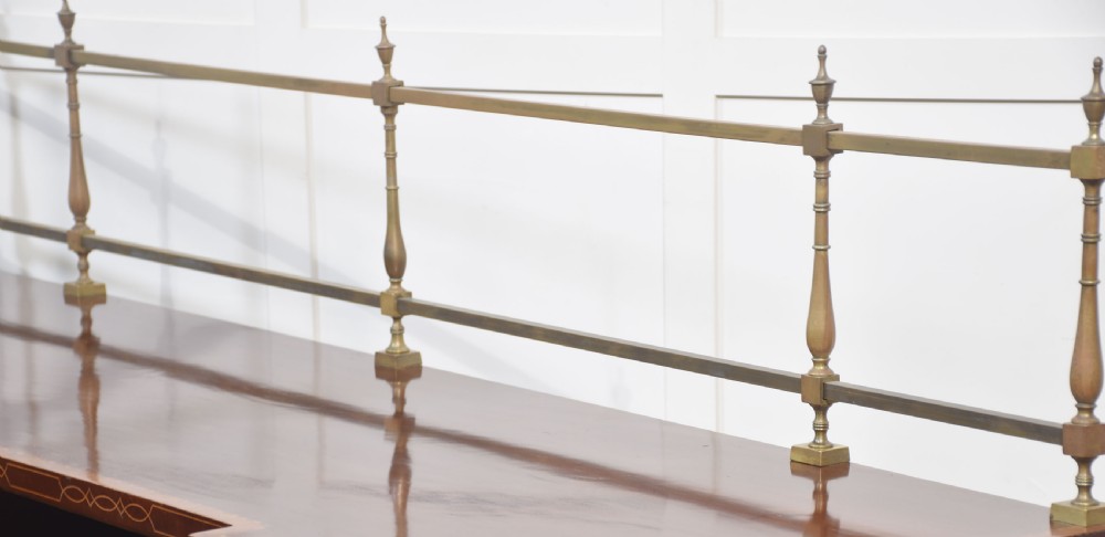 A 19th-century mahogany pedestal sideboard with satinwood oval panel inlays, reeded columns, five upper drawers, and a top brass gallery rail. View XV