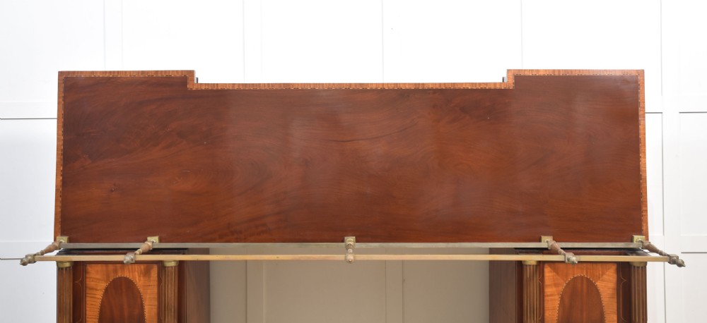 A 19th-century mahogany pedestal sideboard with satinwood oval panel inlays, reeded columns, five upper drawers, and a top brass gallery rail. View XVII