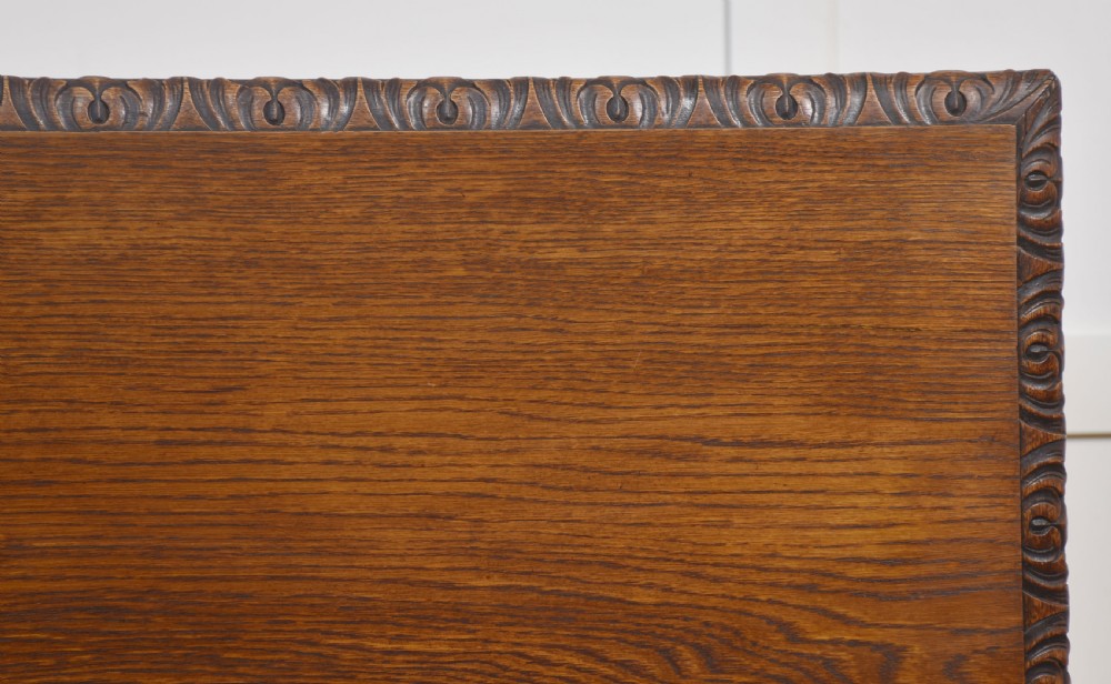 A 19th-century carved oak low cabinet featuring two door panels adorned with central carved roundels and foliate motifs. View II
