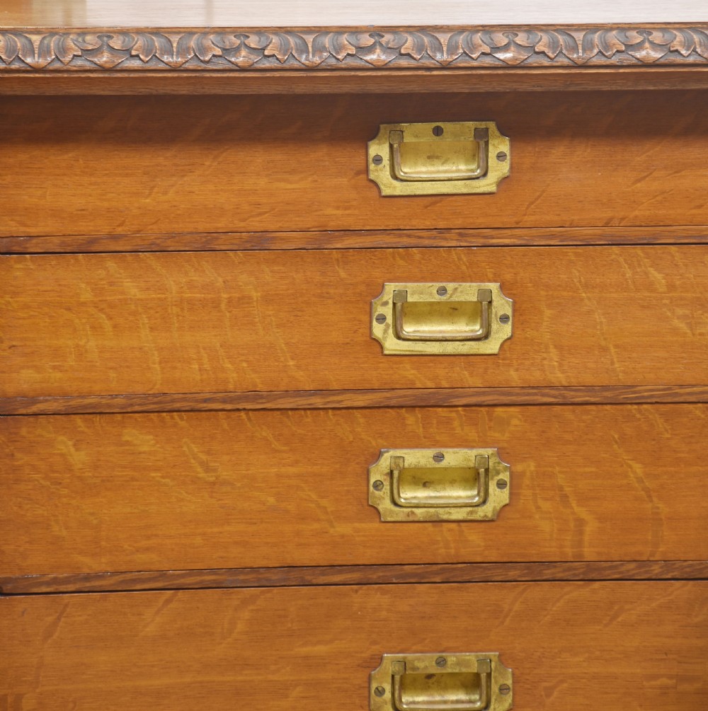 A 19th-century carved oak low cabinet featuring two door panels adorned with central carved roundels and foliate motifs. View VIII
