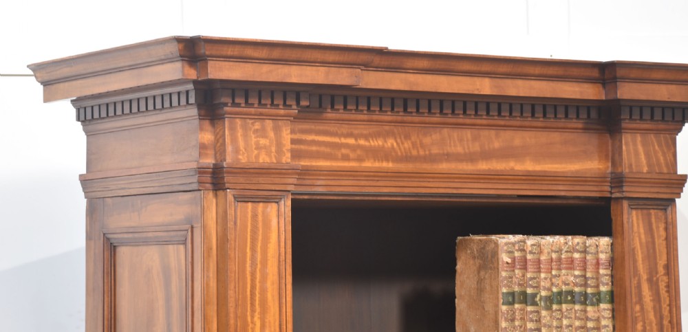 A tall antique golden brown satinwood open bookcase featuring five adjustable shelves, fluted side pilasters, and a moulded top cornice. View III