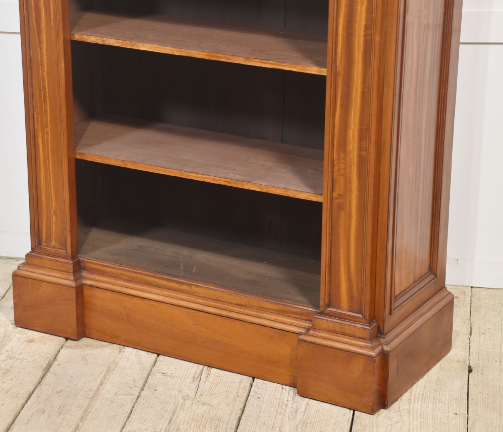 A tall antique golden brown satinwood open bookcase featuring five adjustable shelves, fluted side pilasters, and a moulded top cornice. View IX