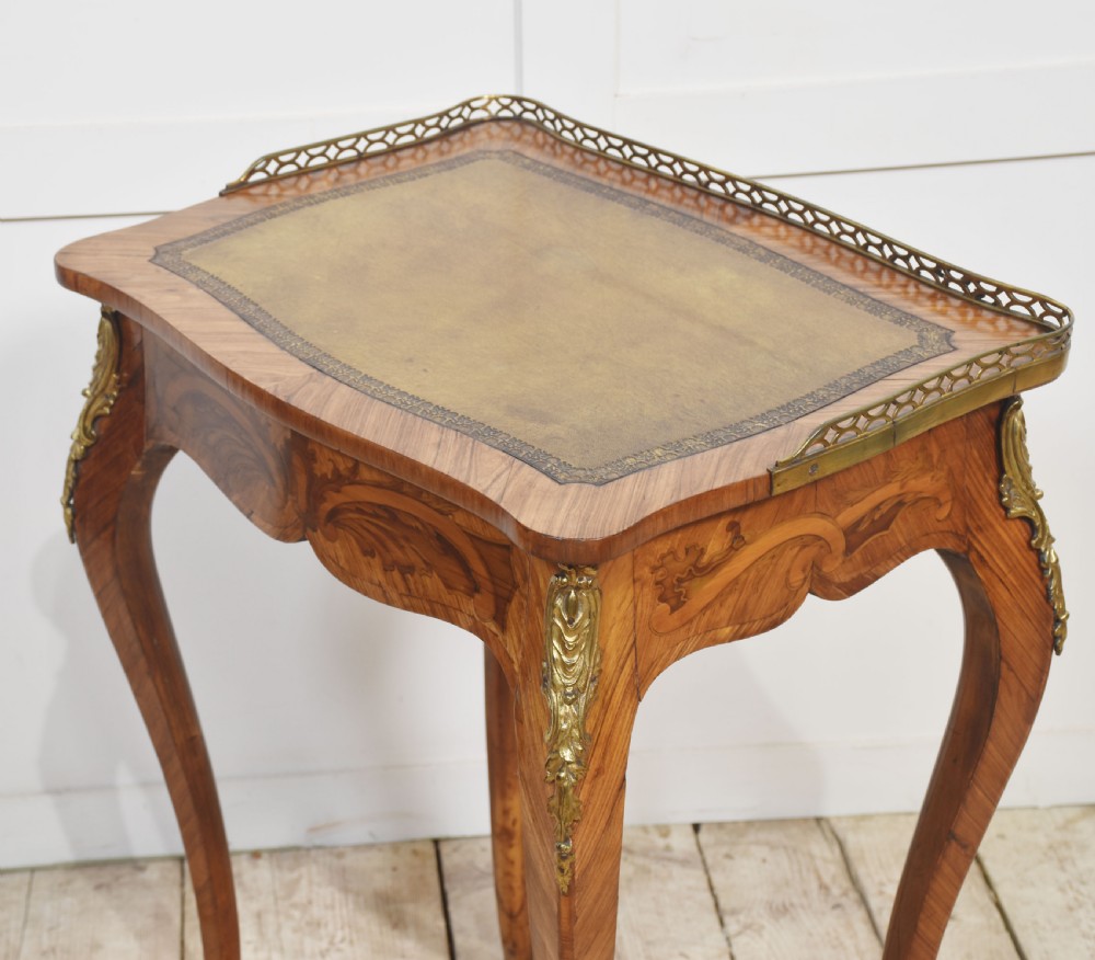 A French Louis XV style kingwood side table featuring a leather inset top with a pierced brass gallery, marquetry inlaid frieze, cabriole legs, and ornate gilt-metal mounts. View IX