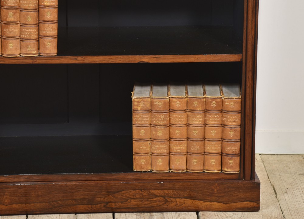A 19th-century dark rosewood open bookcase featuring three tiers of shelving, a gallery top, corner roundels, and a solid plinth base. View II