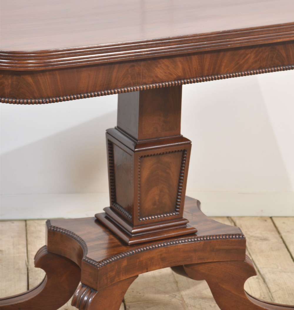 A Regency mahogany tea table featuring a fold-over top, central pedestal support, and four splayed legs with brass paw castors. View IX