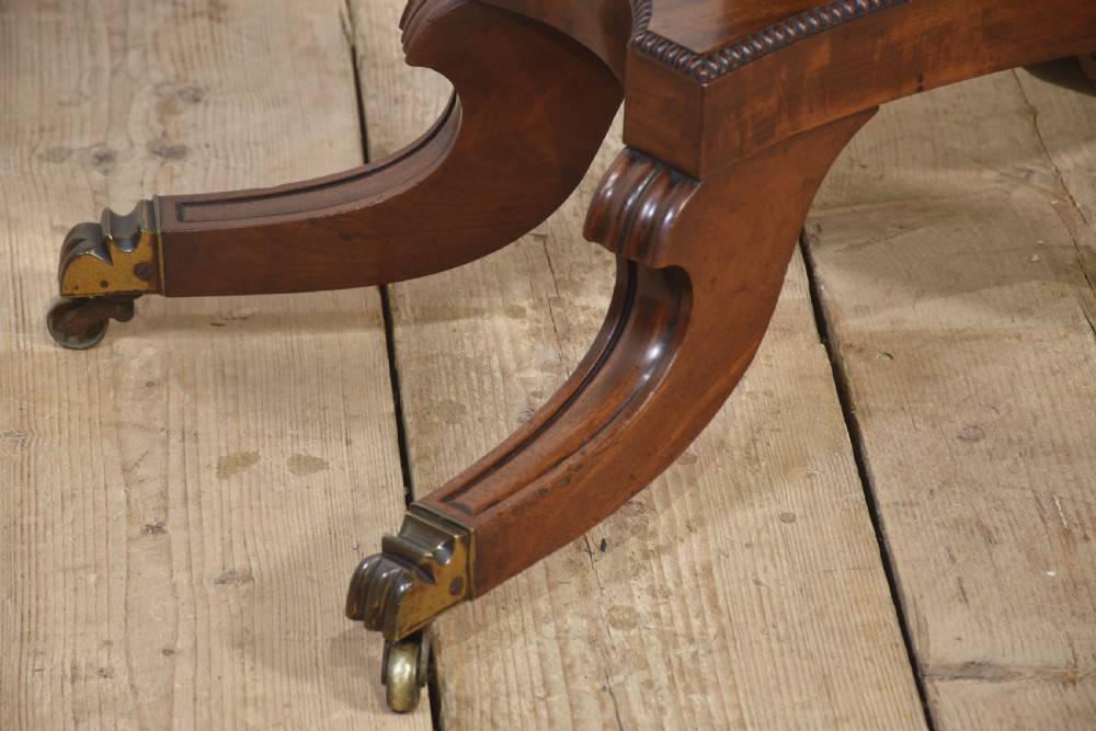 A Regency mahogany tea table featuring a fold-over top, central pedestal support, and four splayed legs with brass paw castors. View XI