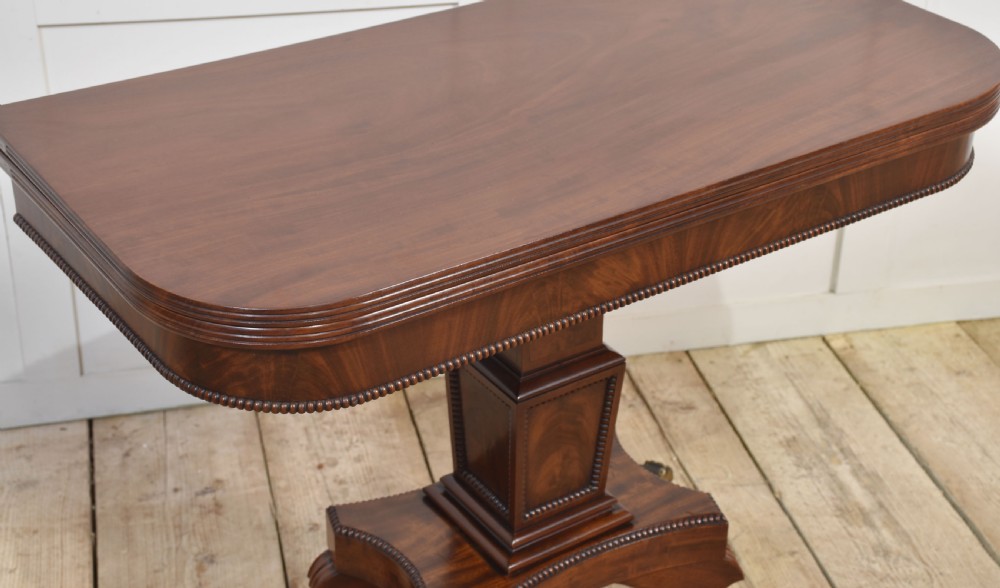 A Regency mahogany tea table featuring a fold-over top, central pedestal support, and four splayed legs with brass paw castors. View XII