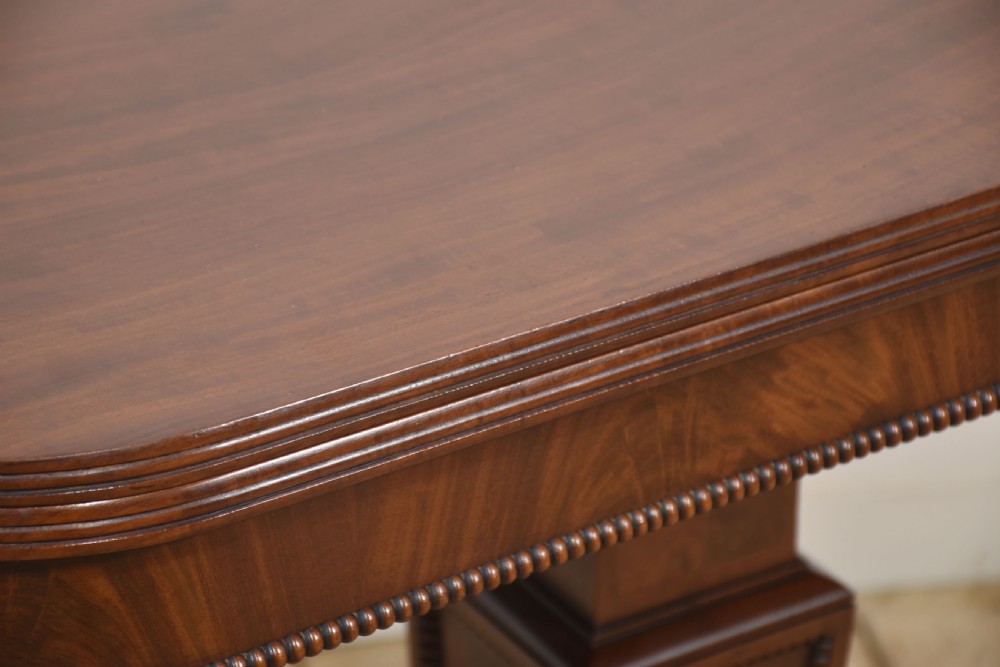 A Regency mahogany tea table featuring a fold-over top, central pedestal support, and four splayed legs with brass paw castors. View XIII