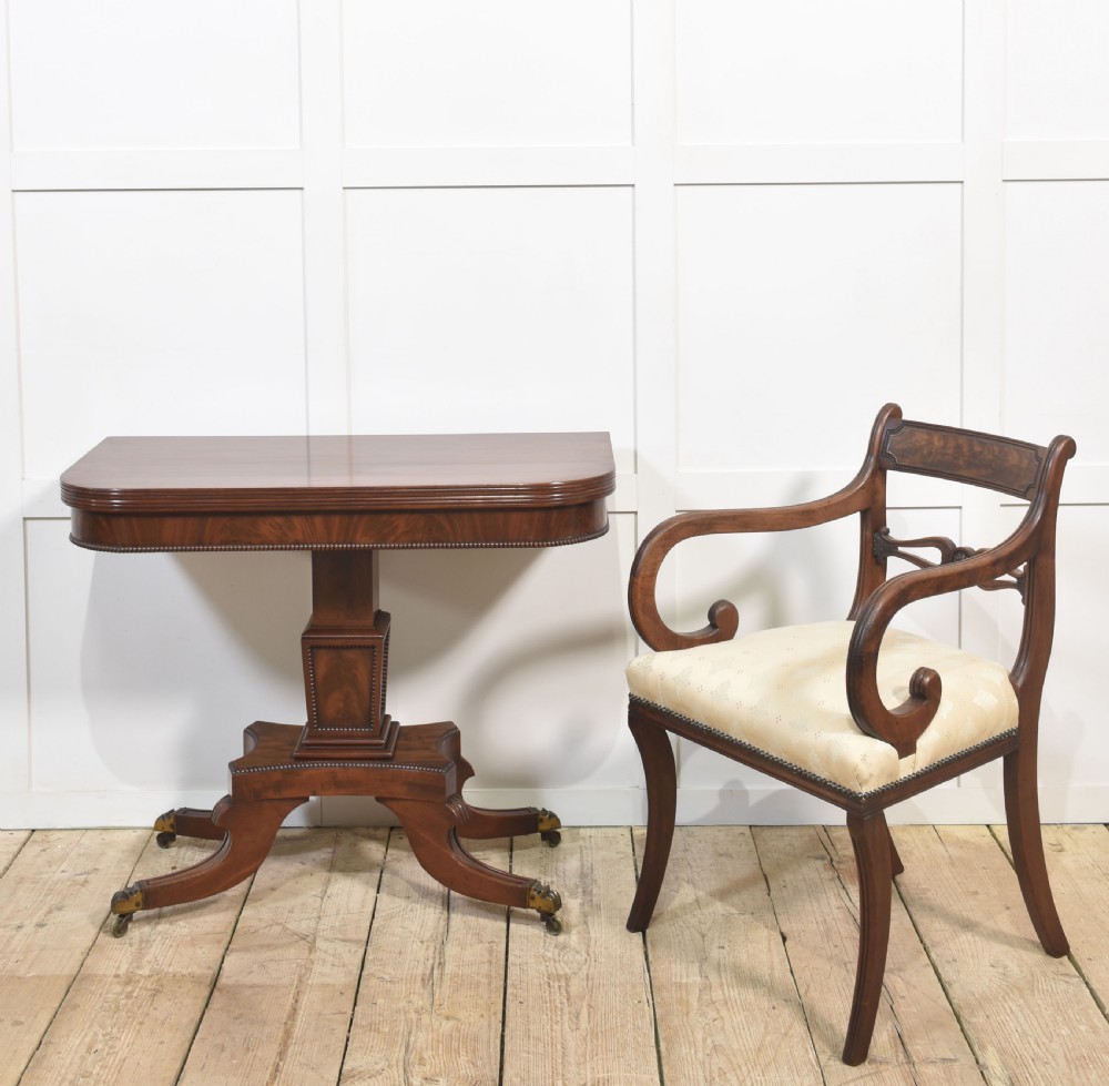 A Regency mahogany tea table featuring a fold-over top, central pedestal support, and four splayed legs with brass paw castors. View XIV