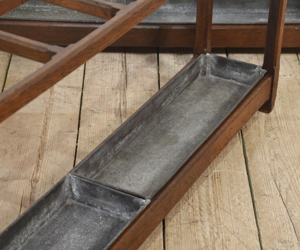 A pair of long dark oak Gothic Revival umbrella stands featuring divided top compartments and metal drip trays. View III
