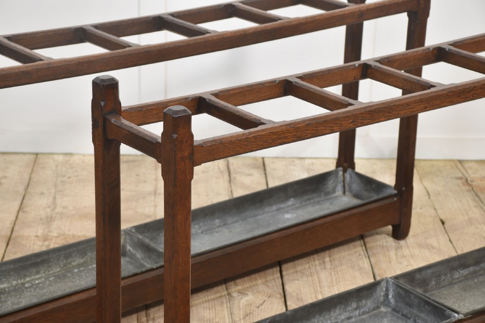 A pair of long dark oak Gothic Revival umbrella stands featuring divided top compartments and metal drip trays. View VII