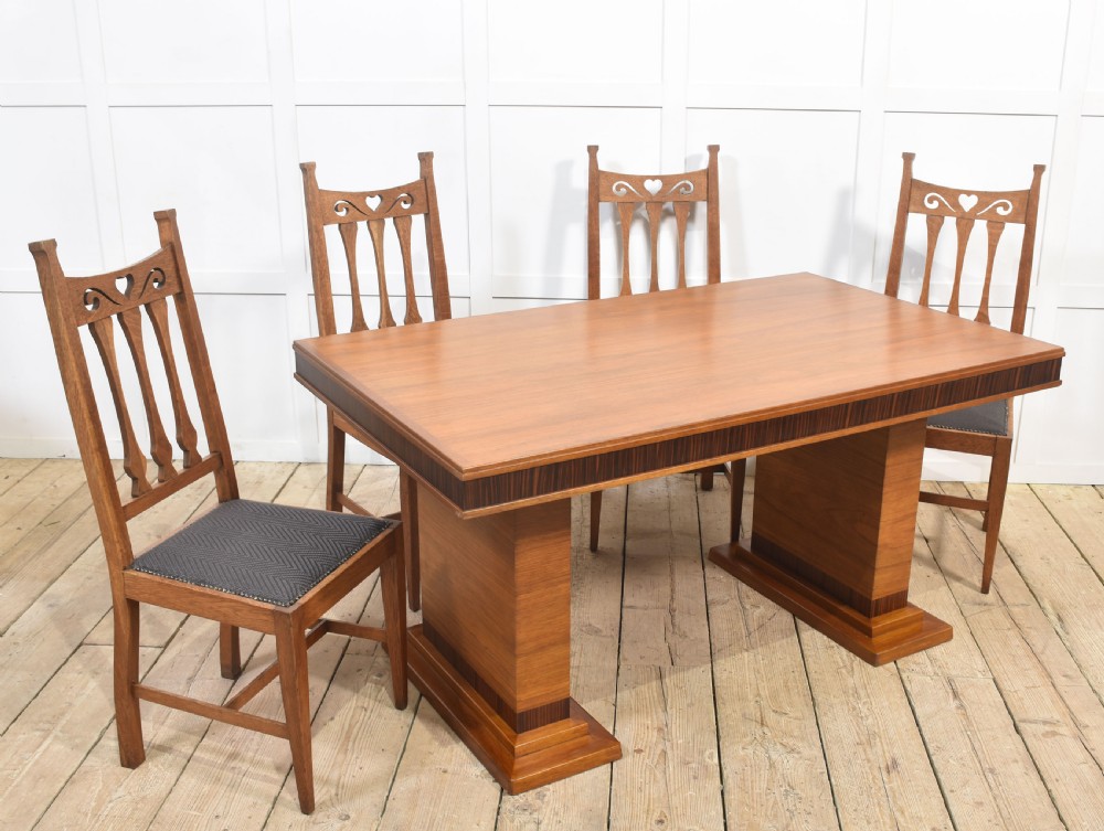 An Art Deco rectangular walnut dining table featuring twin block pedestal supports and dark crossbanded border details along the apron. View II