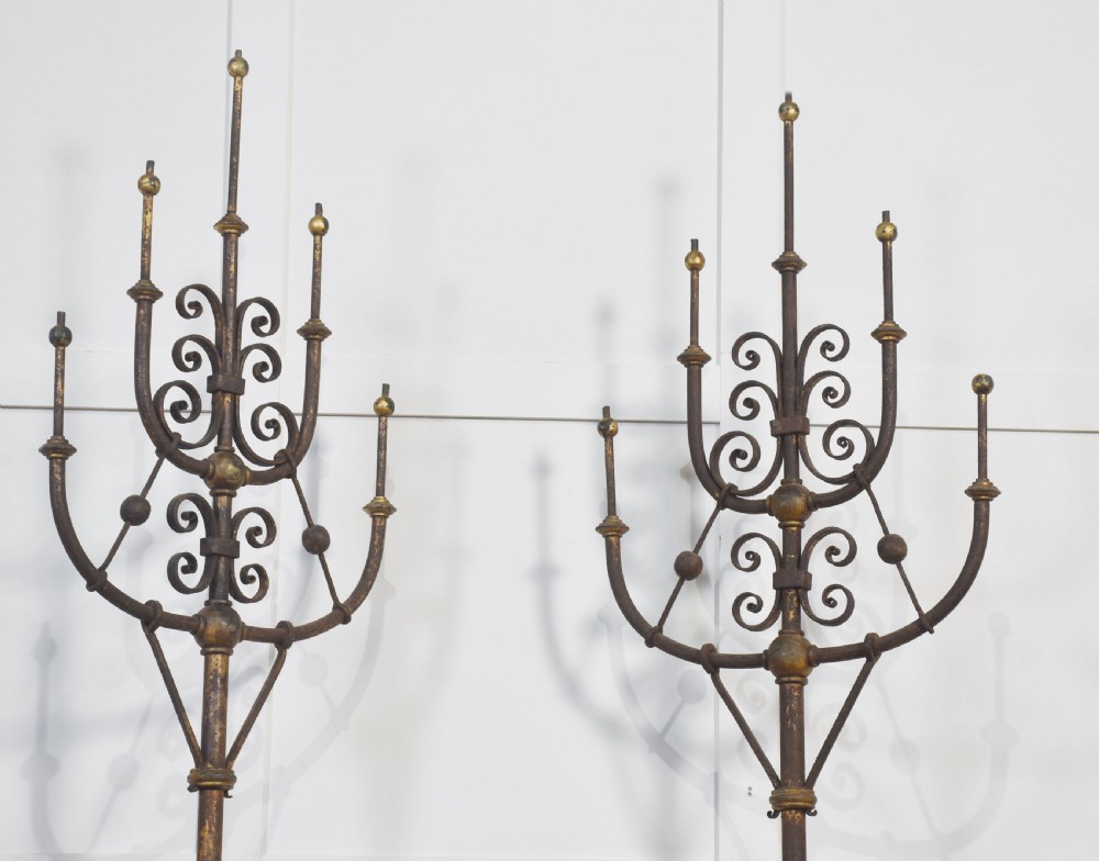 A pair of tall, freestanding cast iron gas light candelabras featuring intricate scrollwork arms and caged open bases. View VII