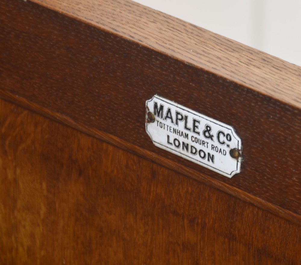 A carved oak two-door sideboard featuring two drawers with brass handles, central rosette carvings on the cupboard doors, and turned columns. View VIII