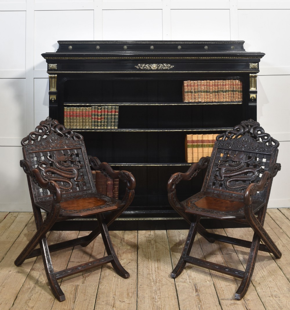 A pair of 19th-century Chinese folding hardwood armchairs featuring intricate dragon carvings on the backrests and serpentine arms supported by X-frame legs. View VII