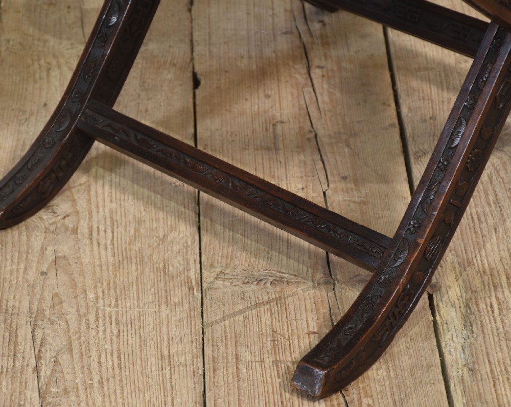 A pair of 19th-century Chinese folding hardwood armchairs featuring intricate dragon carvings on the backrests and serpentine arms supported by X-frame legs. View VIII