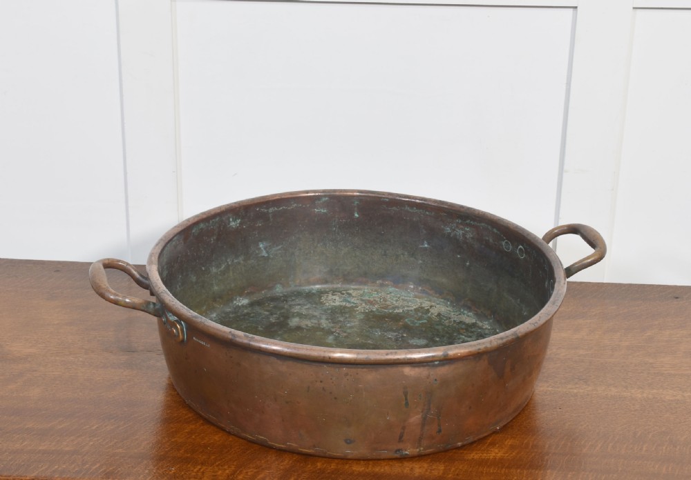 A large, wide, round 19th-century copper preserve pan featuring a rolled rim and two riveted loop handles. View III