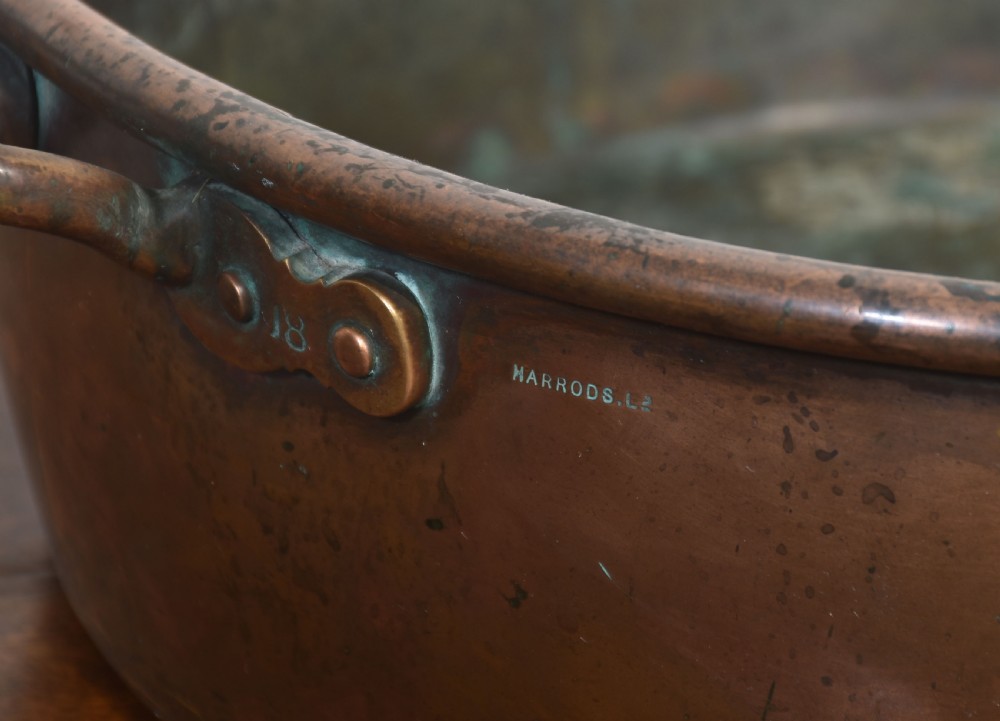 A large, wide, round 19th-century copper preserve pan featuring a rolled rim and two riveted loop handles. View VII