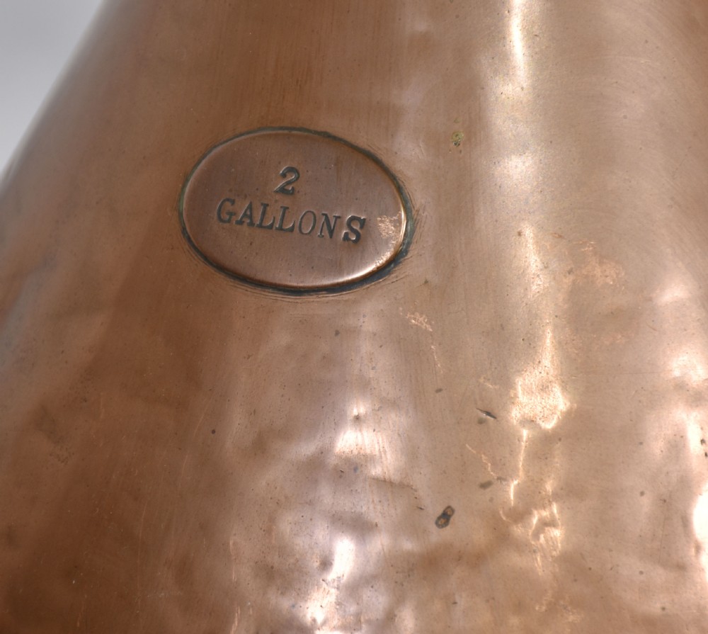 A nineteenth-century hammered copper haystack-shaped liquid measure with a riveted side handle and flared pouring lip. View VIII