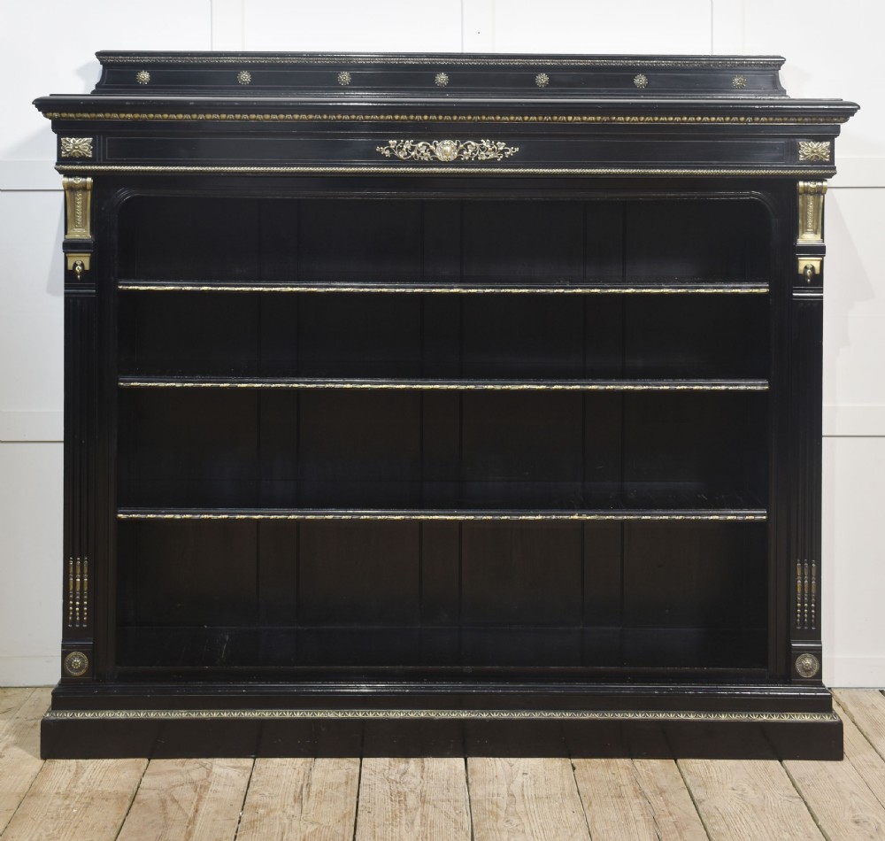 A large black ebonised open bookcase featuring four open shelves decorated with ornate brass mounts and a raised gallery top. View XIV