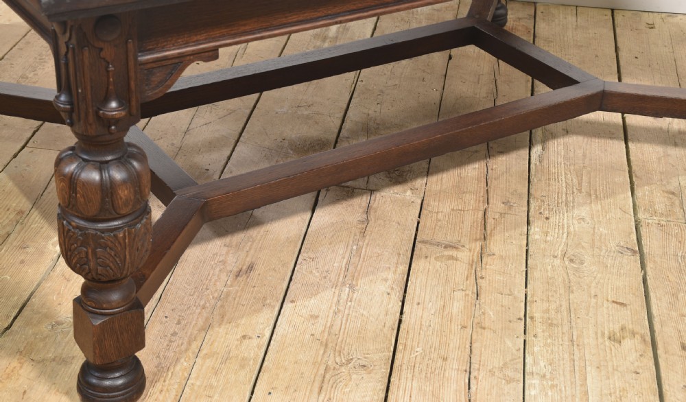 A dark oak extending dining table with carved bulbous legs and an H-stretcher base. View V