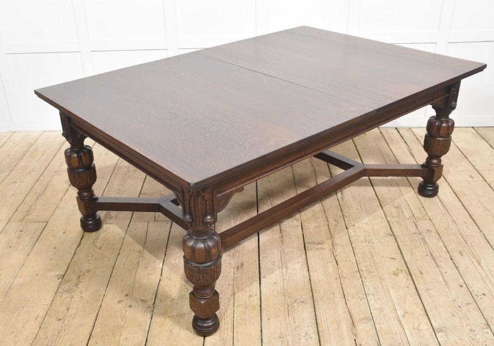 A dark oak extending dining table with carved bulbous legs and an H-stretcher base. View VI