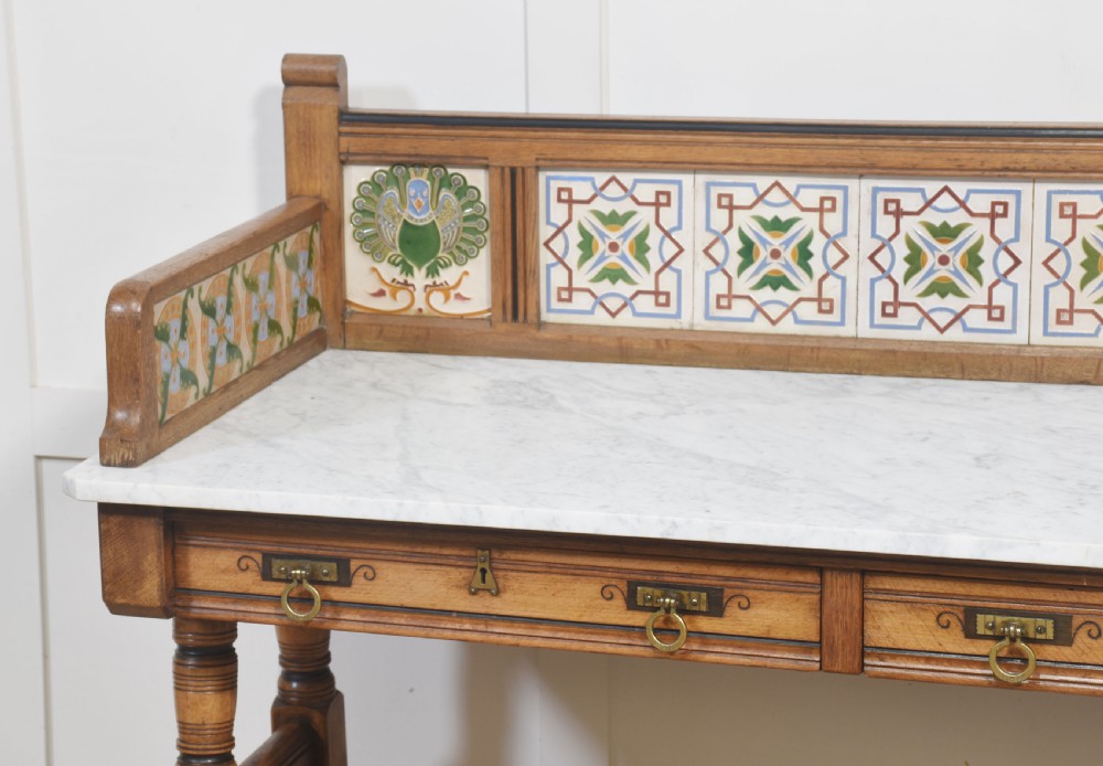 A pair of Aesthetic Movement bedroom tables comprising a marble-top tiled-back washstand and a matching dressing table with tilting mirror. View II