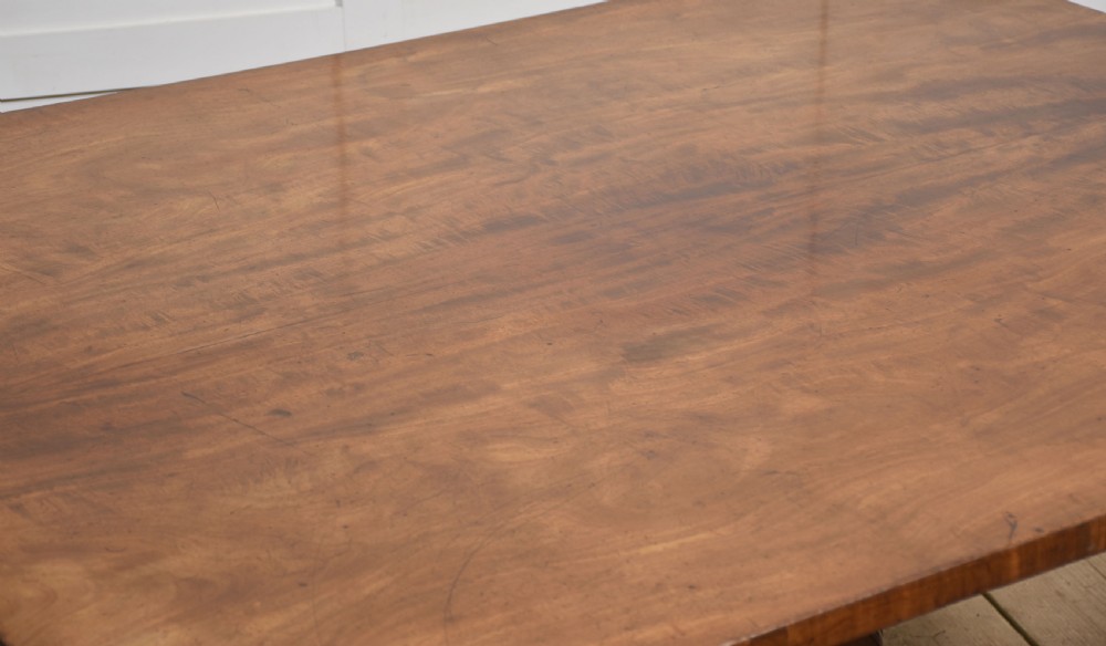 A Regency mahogany tilt-top breakfast table featuring a rectangular top with rounded corners, supported by a turned central pedestal and four splayed legs with brass paw castors. View II
