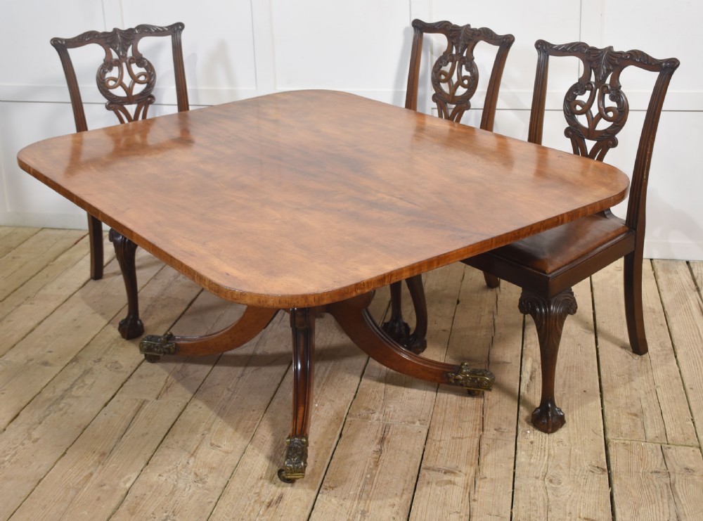 A Regency mahogany tilt-top breakfast table featuring a rectangular top with rounded corners, supported by a turned central pedestal and four splayed legs with brass paw castors. View XII