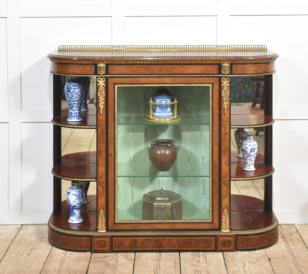 A 19th-century burr walnut credenza featuring a central glass door flanked by open curved shelves with mirrored backs and gilt-brass mounts. View II