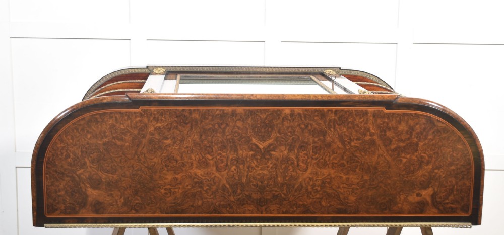 A 19th-century burr walnut credenza featuring a central glass door flanked by open curved shelves with mirrored backs and gilt-brass mounts. View XVII