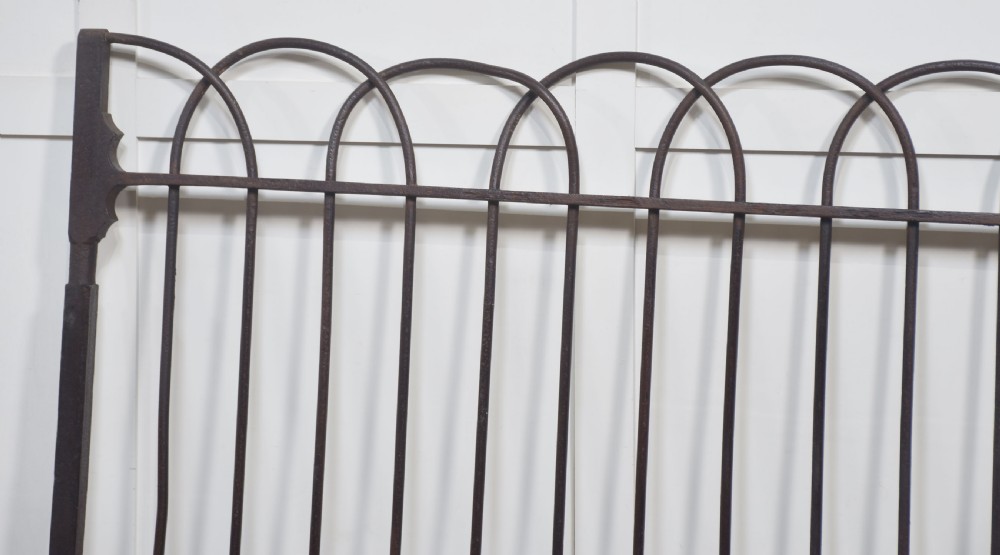 A pair of 19th-century wrought and cast iron gates featuring arched hoop tops, vertical pales, and central spearhead finials. View II