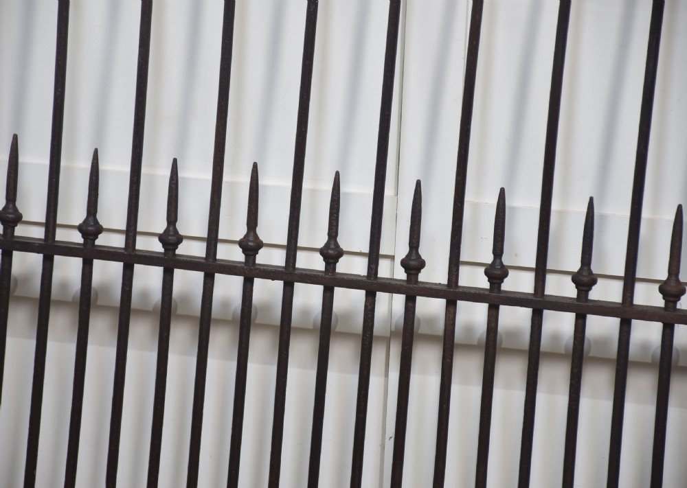 A pair of 19th-century wrought and cast iron gates featuring arched hoop tops, vertical pales, and central spearhead finials. View III