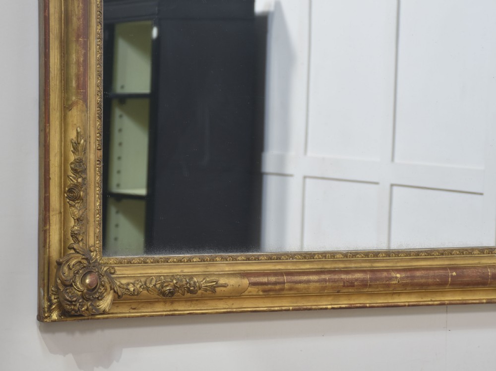 A large rectangular 19th-century wall mirror with a carved giltwood frame featuring ornate floral corner spandrels and moulded edges. View XIII
