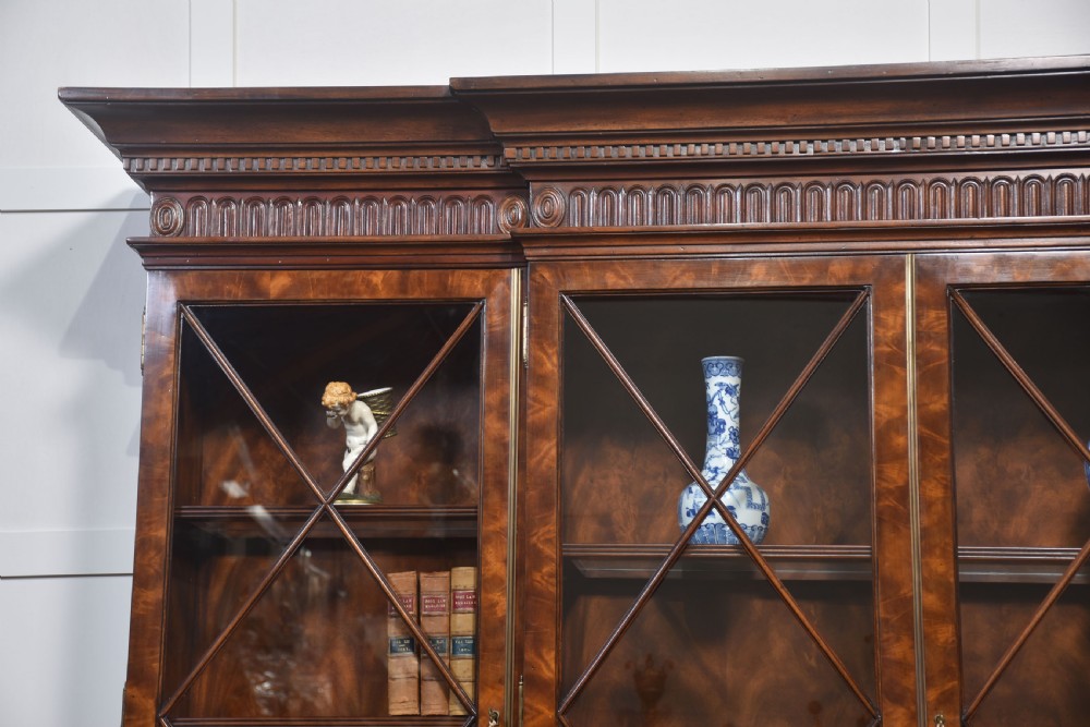 A large George III style mahogany breakfront library bookcase featuring glazed upper doors with astragal bars and a lower base with drawers and panelled cupboards. View VI