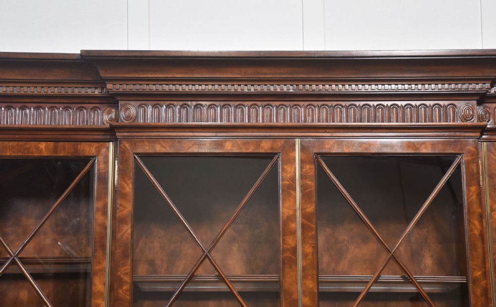 A large George III style mahogany breakfront library bookcase featuring glazed upper doors with astragal bars and a lower base with drawers and panelled cupboards. View XI