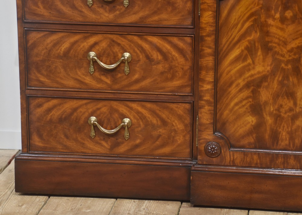 A large George III style mahogany breakfront library bookcase featuring glazed upper doors with astragal bars and a lower base with drawers and panelled cupboards. View XIV