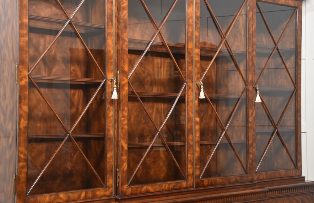 A large George III style mahogany breakfront library bookcase featuring glazed upper doors with astragal bars and a lower base with drawers and panelled cupboards. View XVIII