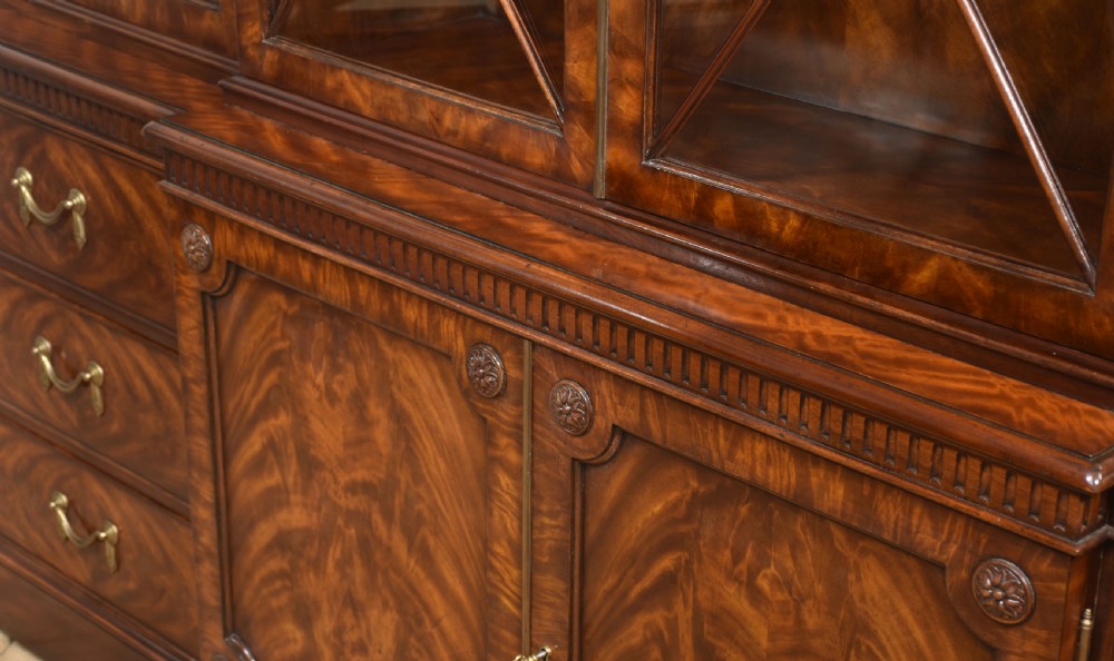 A large George III style mahogany breakfront library bookcase featuring glazed upper doors with astragal bars and a lower base with drawers and panelled cupboards. View XX